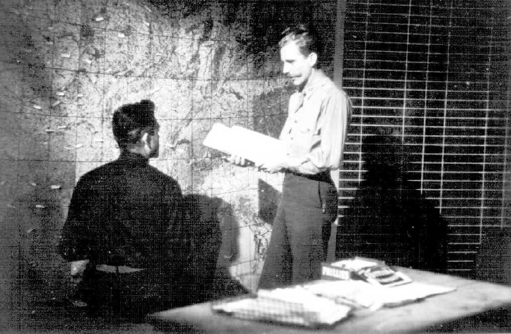 Robert D Sullivan standing in front of the Operations Room map